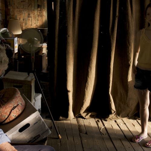 Abner (Hal Holbrook) is visited by Pamela (Mia Wasikowska) inside the dark tenant shack