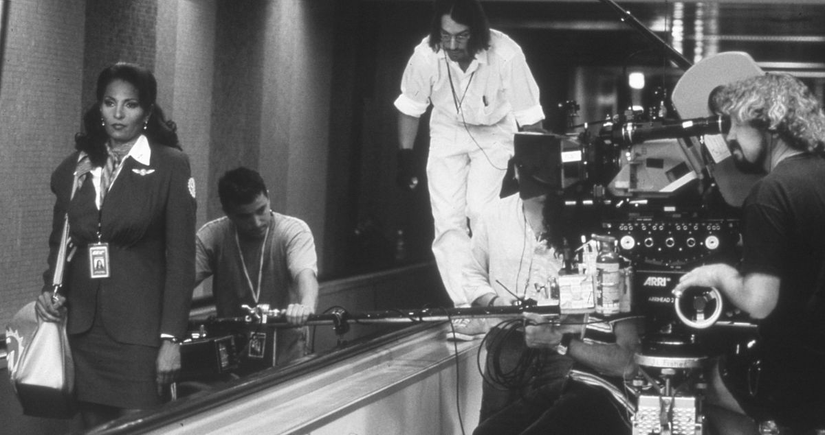 Shooting Quentin Tarantino’s 1997 crime drama Jackie Brown, Steadicam/A-camera operator Kneece (behind camera), key grip Rick Stribling (on ledge) and dolly grip Robert “Dolly Bob” Ivanjack execute the film’s opening sequence — an extensive tracking shot on actress Pan Grier hustling through Los Angeles International Airport.